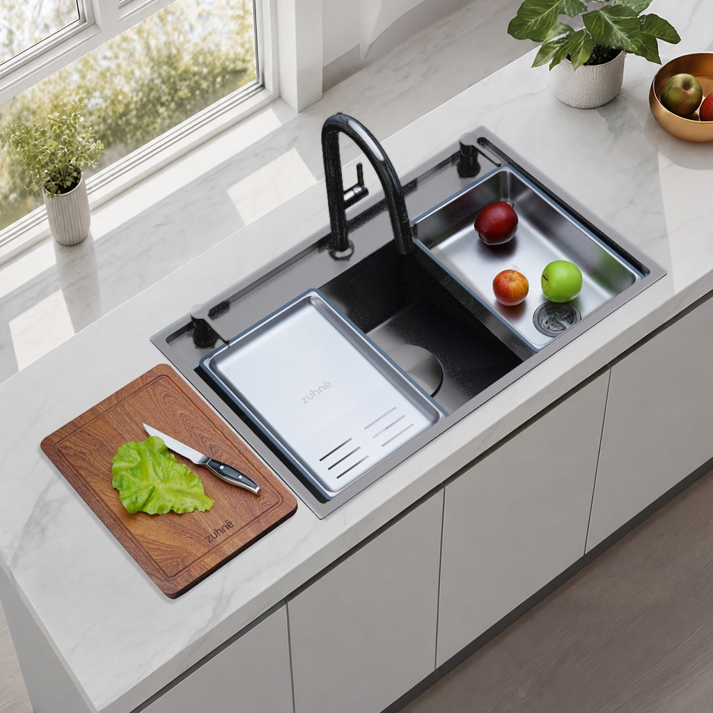 Oslo Lunar Gunmetal workstation sink with black pull-down faucet, a defrosting tray and soak and rinse bin on the sink, with a cutting board on the counter